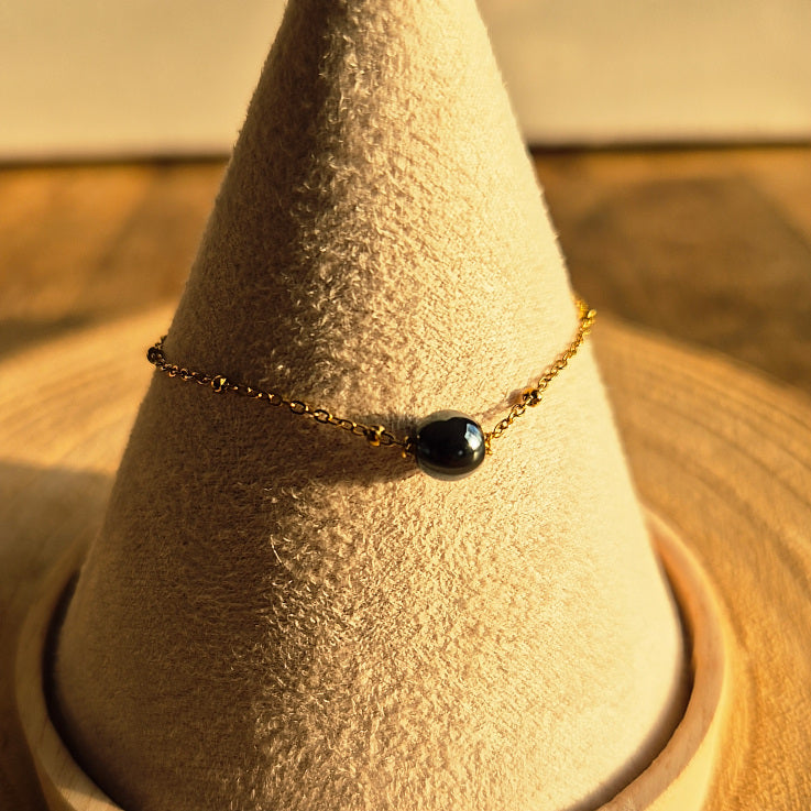 Bracelet fin en Hématite naturelle 6 mm sur chaîne dorée en acier inoxydable, création artisanale Les Secrets de G&M.