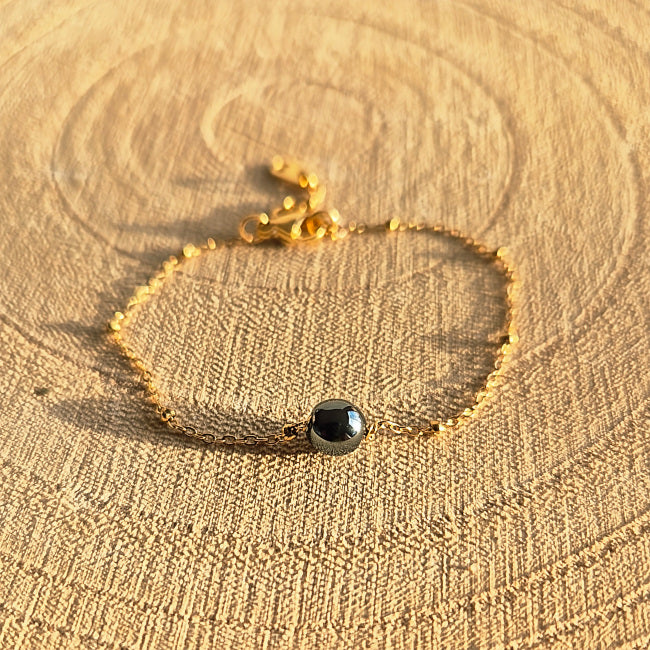 Bracelet fin en Hématite naturelle 6 mm sur chaîne dorée en acier inoxydable, création artisanale Les Secrets de G&M.