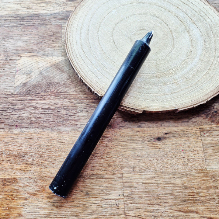 Bougie noire allumée, symbole de protection, de purification et de transformation. Utilisée pour libérer les énergies négatives et favoriser la renaissance intérieure.