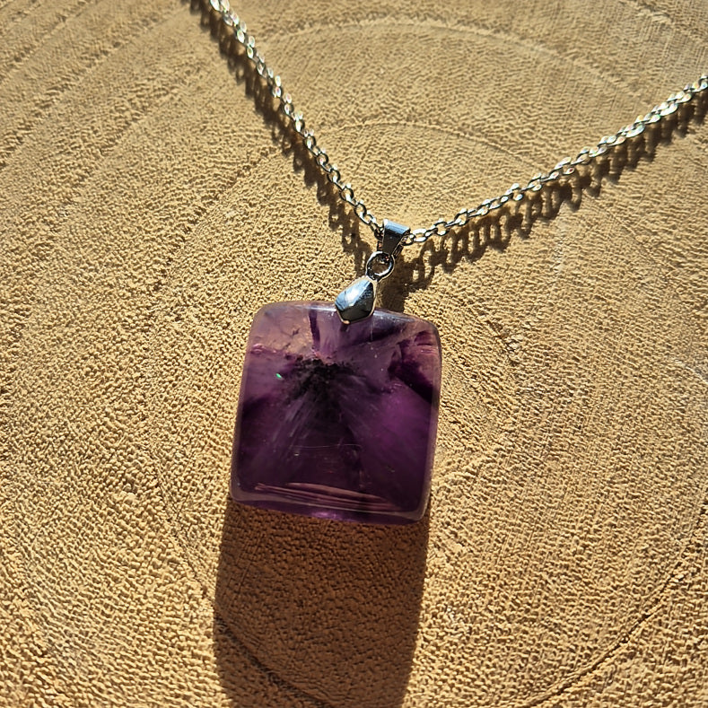 Collier avec pendentif carré en améthyste violette sur chaîne.