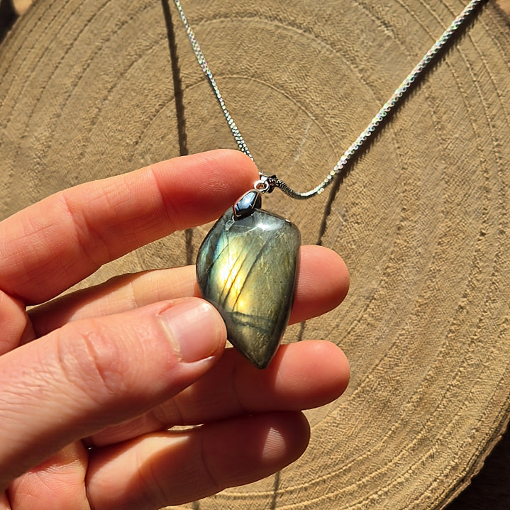 Collier avec pendentif en labradorite aux reflets bleus irisés sur chaîne.