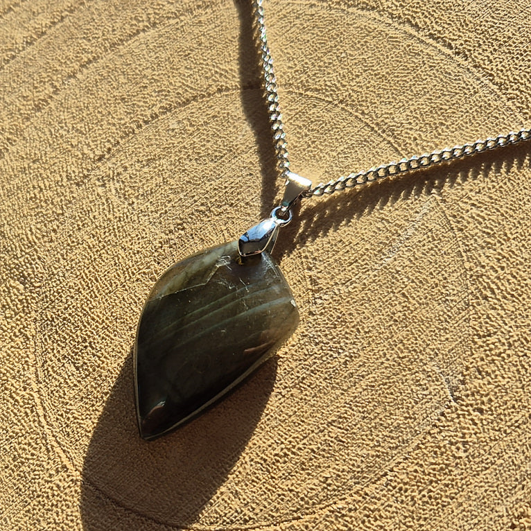 Collier avec pendentif en labradorite aux reflets bleus irisés sur chaîne.