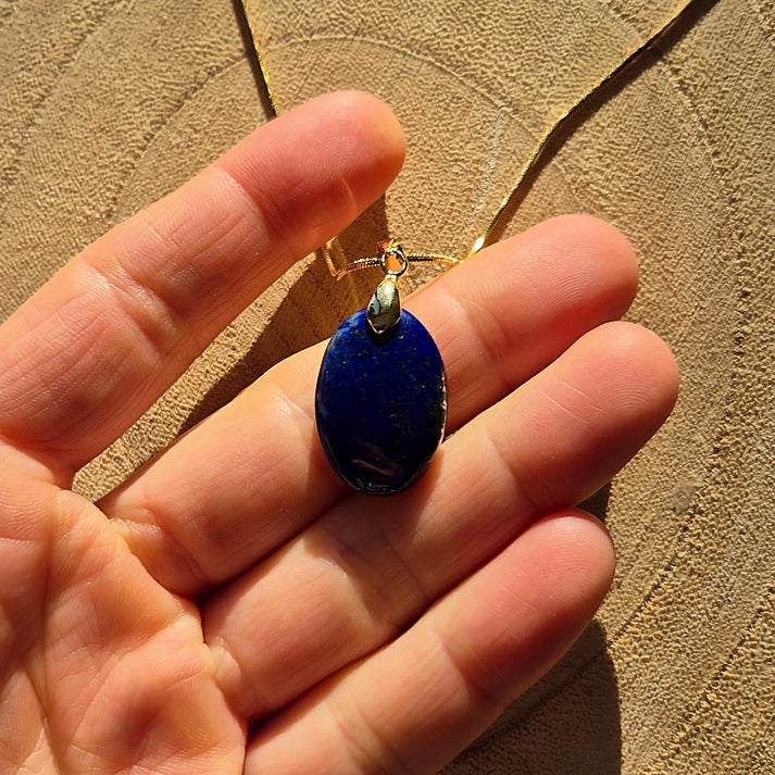 Collier avec pendentif en lapis lazuli bleu profond sur chaîne dorée.