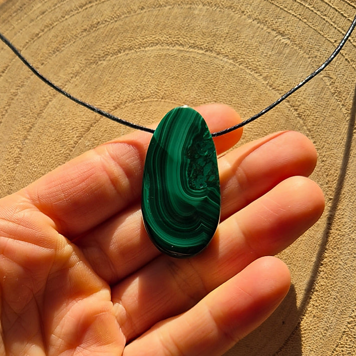Collier avec pierre percée en malachite verte à bandes naturelles d’environ 3,5 cm.