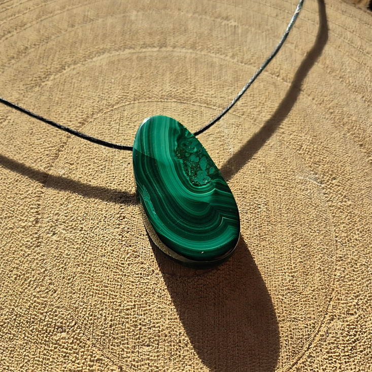 Collier avec pierre percée en malachite verte à bandes naturelles d’environ 3,5 cm.