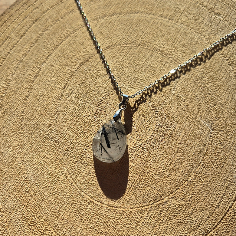 Collier avec pendentif goutte en quartz tourmaliné transparent avec inclusions noires.