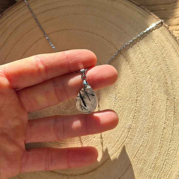 Collier avec pendentif goutte en quartz tourmaliné transparent avec inclusions noires.